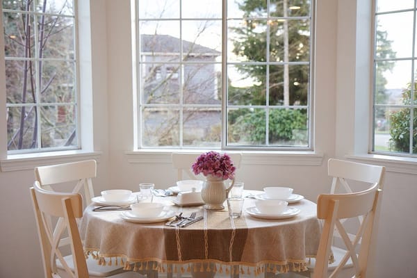 A dining table set for a meal with flowers