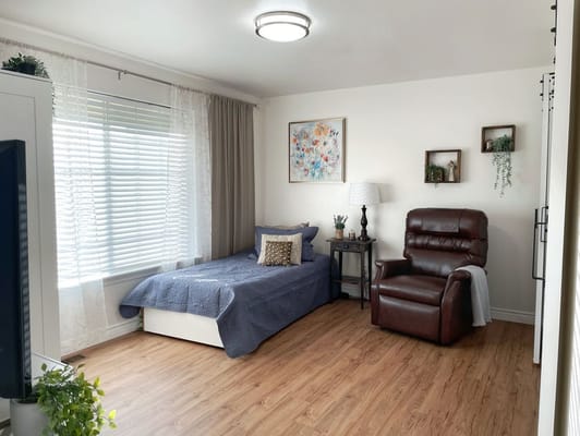 Cozy interior of a resident's room with a chair and bed