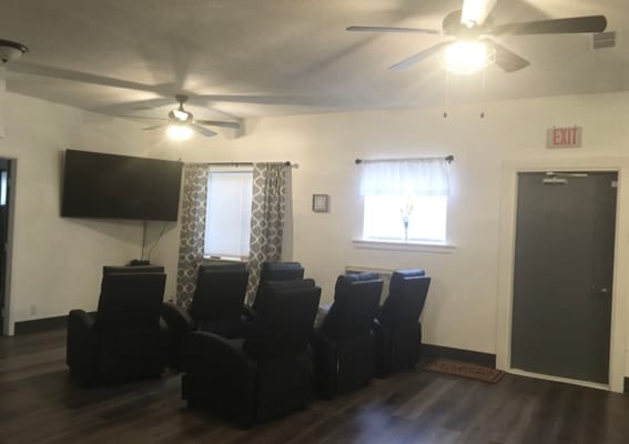 A cozy seating area with reclining chairs and a TV