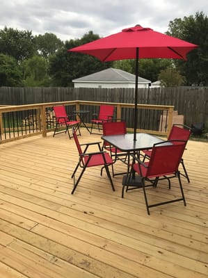 Outdoor space with red chairs and an umbrella