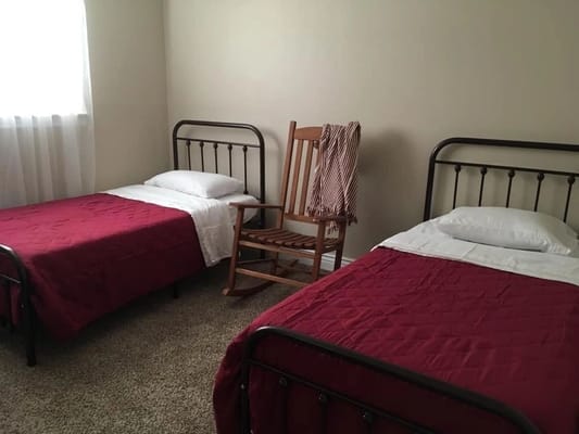 A shared resident room with two beds and a rocking chair