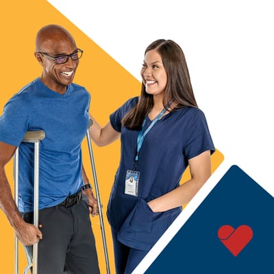 A nurse assists a smiling resident with crutches