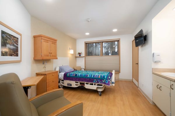 Private resident room with a bed and armchair