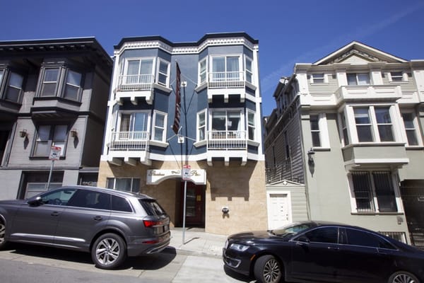 Exterior view of a senior living facility with vehicles