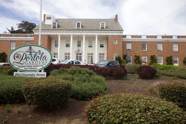 Front view of Portola Gardens assisted living facility with landscaping.