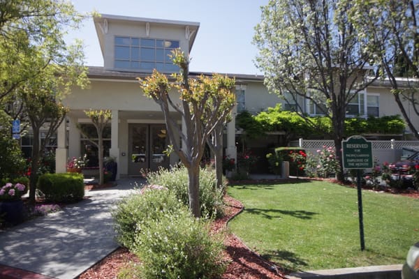 Front entrance of Pacific Gardens with flowers and signage