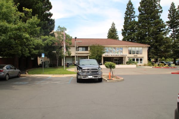 Exterior view of Mercy McMahon Terrace facility with parking