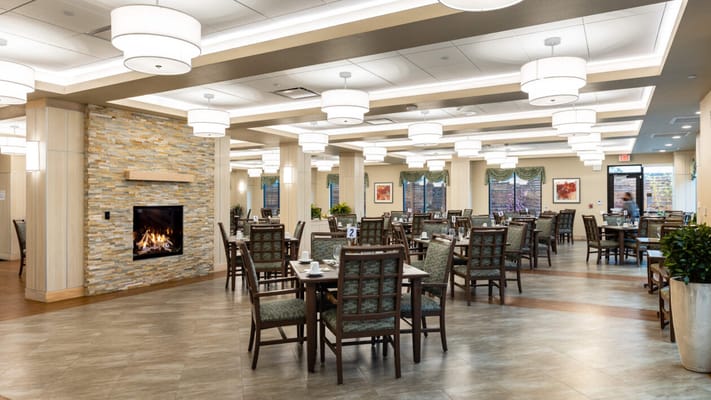 Bright and modern dining area with fireplace and tables