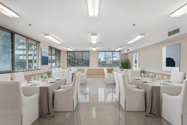Brightly lit dining room with neatly arranged tables and chairs