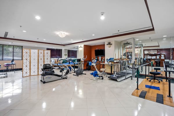Modern therapy room equipped with exercise machines and rehabilitation equipment.