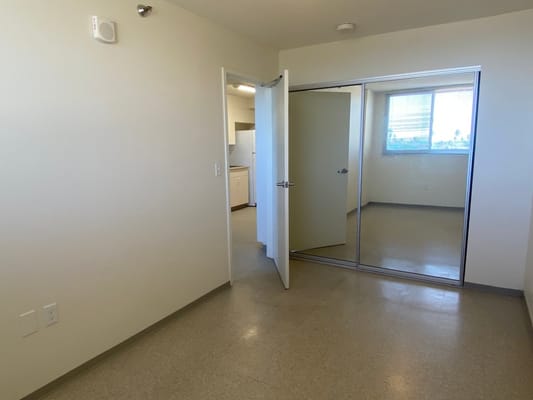 Empty room with an open door and mirror closet