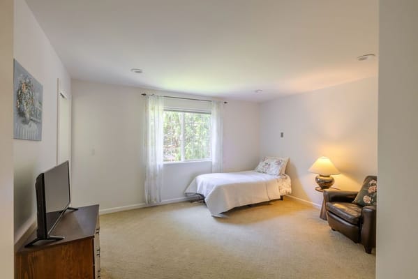 A private resident room with a bed and a lamp