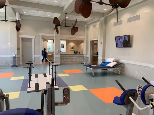 Rehabilitation room with equipment and staff member