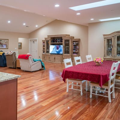 Bright dining area with wooden flooring and large TV