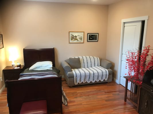 Cozy private resident room with a bed and sofa