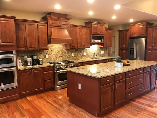 Modern kitchen area with wooden cabinets and granite countertops