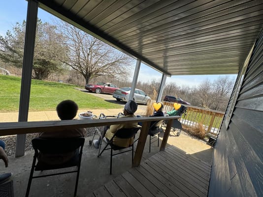 Group of residents seated on a porch, enjoying the outdoors.