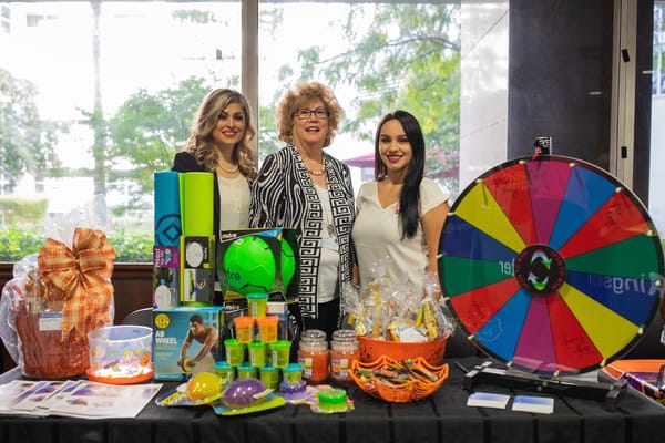 Staff members with event prizes at a community activity