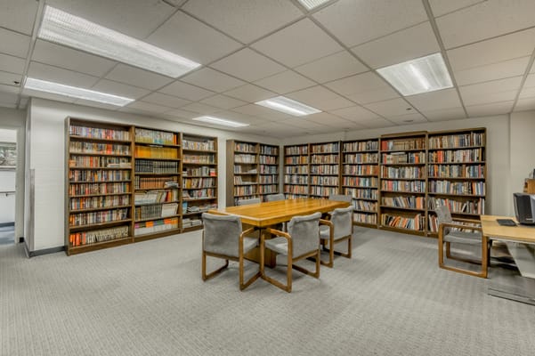 Interior view of a library with bookshelves and a table