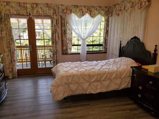 Cozy resident room with floral curtains and a bed
