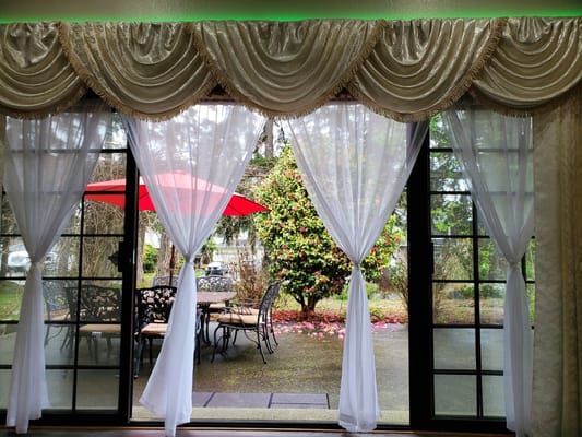 View of an outdoor patio through sheer curtains