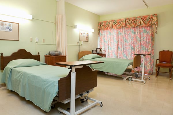 A shared resident room with two beds and a window