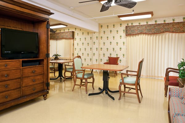 Common area with table and chairs in a senior living facility