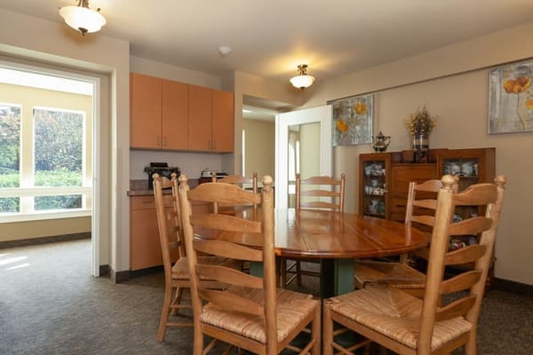Well-lit dining area with wooden table and chairs