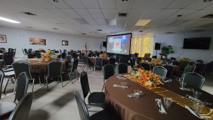 Dining room with decorated tables and a projector screen