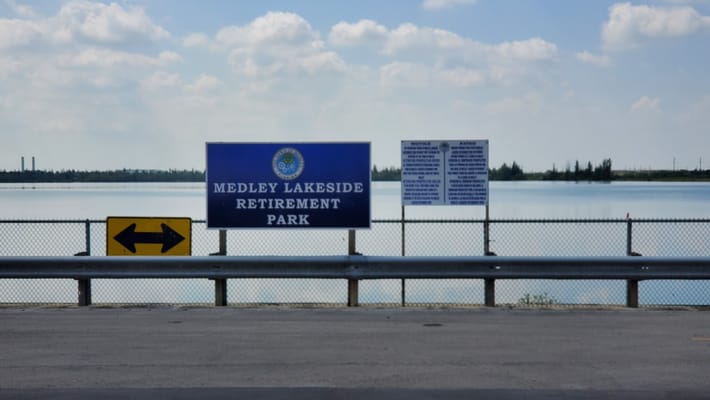 Sign for Medley Lakeside Retirement Park with lake in the background