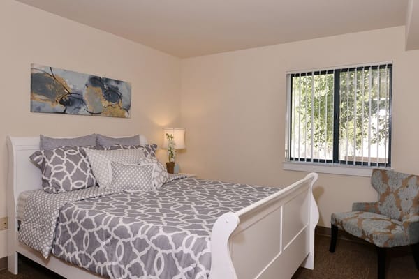 Cozy resident bedroom with bed and artwork