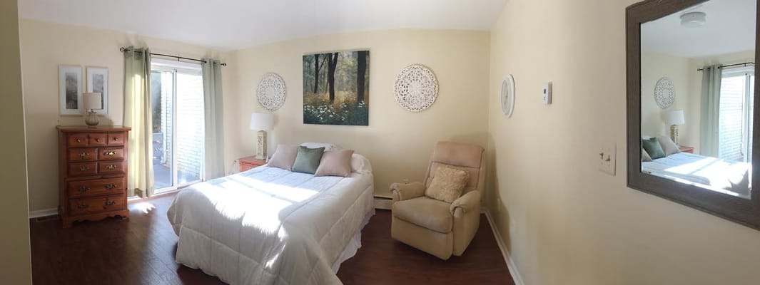 A bright, spacious resident room with a bed and chair