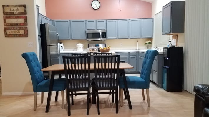 Bright kitchen with dining table and blue chairs