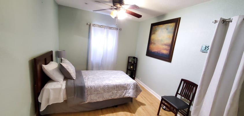 A cozy resident room with a bed and artwork