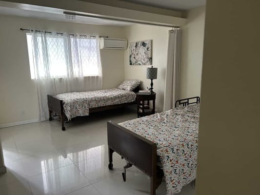 Bright bedroom with two beds and a lamp