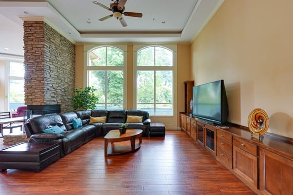Spacious living room with leather sectional and large windows