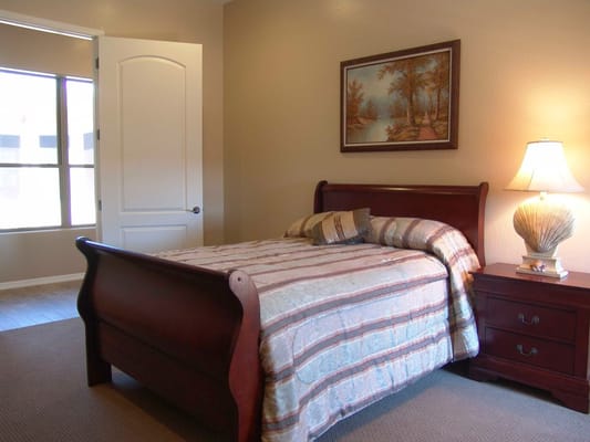 Well-furnished bedroom with a bed, nightstand, and window