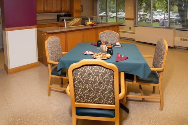 A dining area table set with plates and drinks.