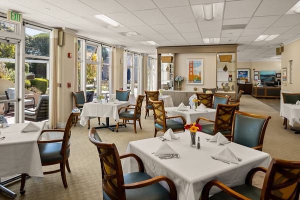Bright and inviting dining area with tables set for meals at Sagebrook Senior Living.