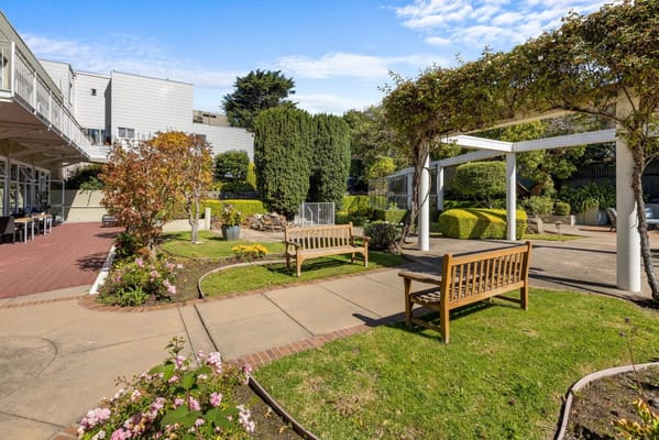 A peaceful garden area with benches and pathways at Sagebrook Senior Living.