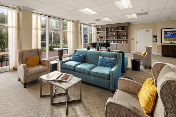 Cozy living room with seating and bookshelves at Sagebrook Senior Living