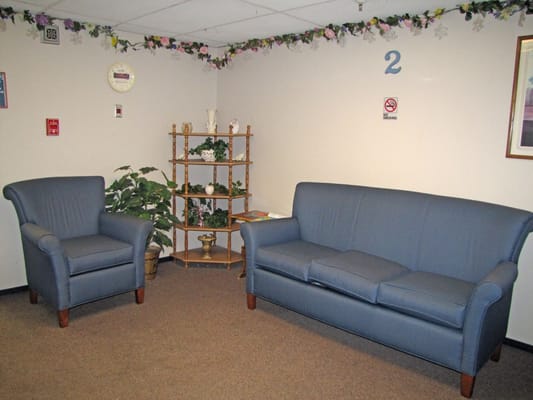Seating area with blue couch and armchair in a lounge