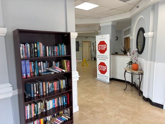 Interior view of a common area with books and a reception desk