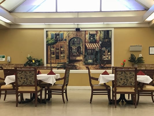 Dining area with tables and a mural in the background