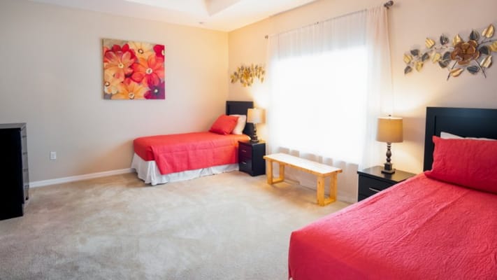 Bright bedroom with two twin beds and decorative flowers on the wall