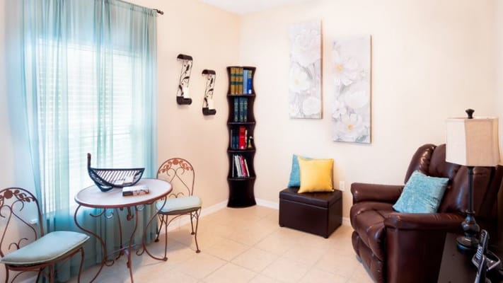 A cozy living area with a table, decorative curtains, and comfortable seating.