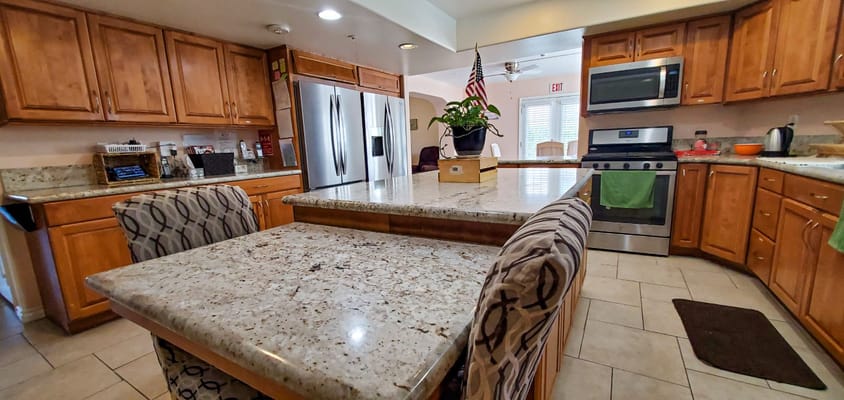 Bright kitchen area with wooden cabinets and granite countertops