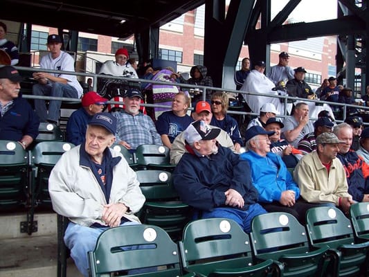 Senior residents sitting in bleachers at a baseball game