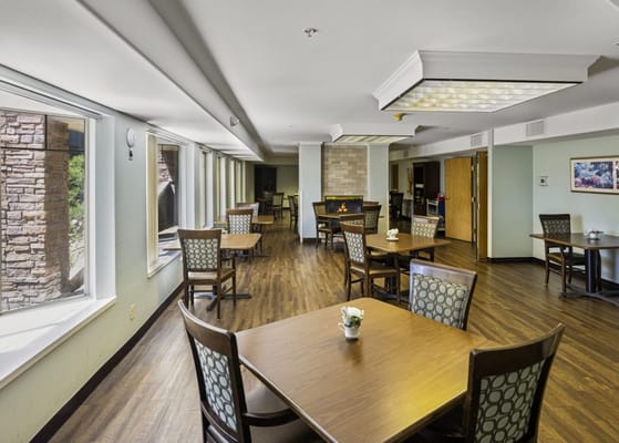 Spacious dining area with tables and chairs, large windows, and a cozy atmosphere.