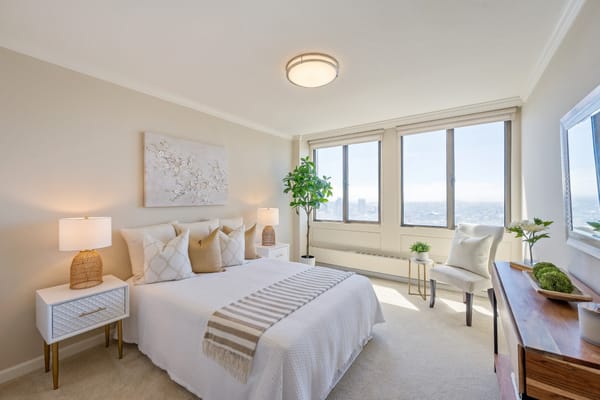 Brightly decorated bedroom with large windows and modern furnishings